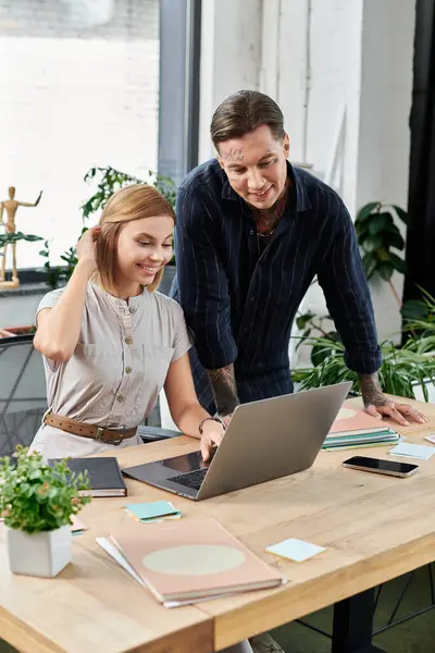 Two young professionals engage in a productive discussion while working on a laptop together. — Stock Photo
