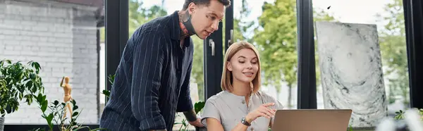 Two young professionals share ideas while working together at a laptop in a bright office. — Stock Photo