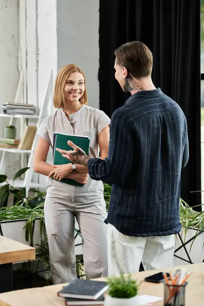 Two coworkers are sharing ideas and laughing together in their bright workspace. — Stock Photo