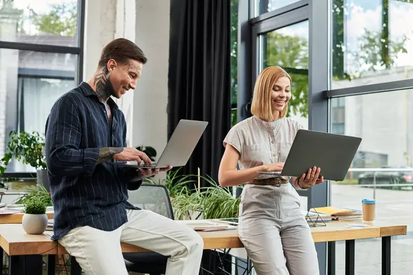 Two young coworkers collaborate at a chic office desk, boosting teamwork and creativity. — Stock Photo