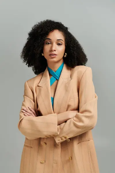 Dressed in stylish attire, a woman stands with confidence, radiating sophistication and grace. — Stock Photo