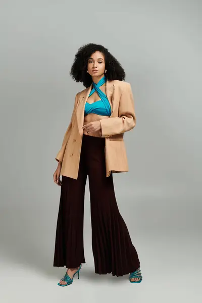 A fashionable woman confidently poses in elegant attire, exuding contemporary style. — Stock Photo