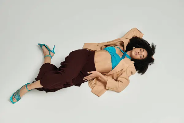 A fashionable woman effortlessly showcases her unique style while reclining gracefully. — Stock Photo