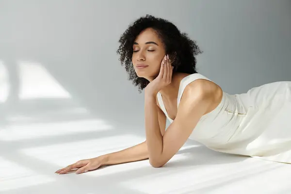 A stylish woman reclines gracefully, embracing tranquility in a soft lit space. — Stock Photo