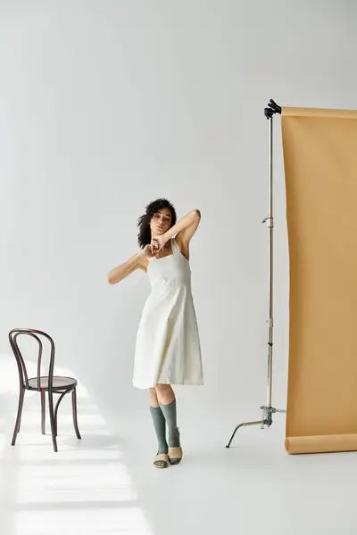 A fashionable woman showcases her unique style in a serene studio setting, exuding confidence. — Stock Photo