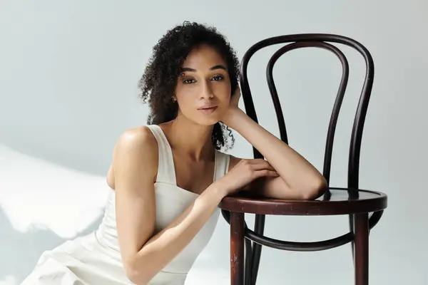 Une femme élégante met en valeur la mode élégante tout en se reposant à côté d'une chaise en bois classique. — Stock Photo