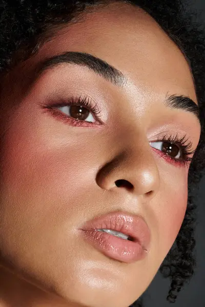 Una mujer de moda destaca su maquillaje único y aspecto elegante mientras posa al aire libre. - foto de stock