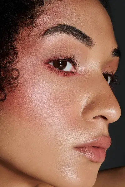 A stylish woman highlights her exquisite makeup artistry with confidence and allure. — Stock Photo