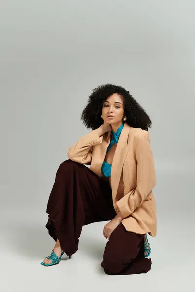 The alluring woman showcases her unique fashion sense while kneeling gracefully. — Stock Photo