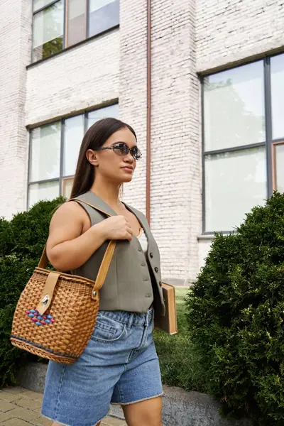 A stylish brunette woman with a short stature strolls through a vibrant urban setting, enjoying a lovely day outdoors. — Stock Photo