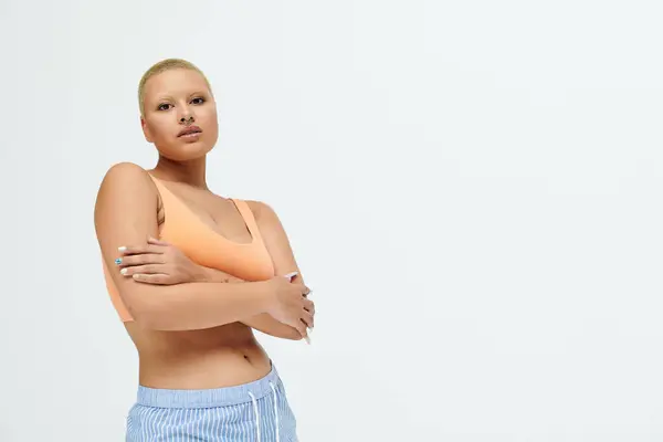 A bald woman poses powerfully in eye catching clothing, radiating confidence and style. — Stock Photo