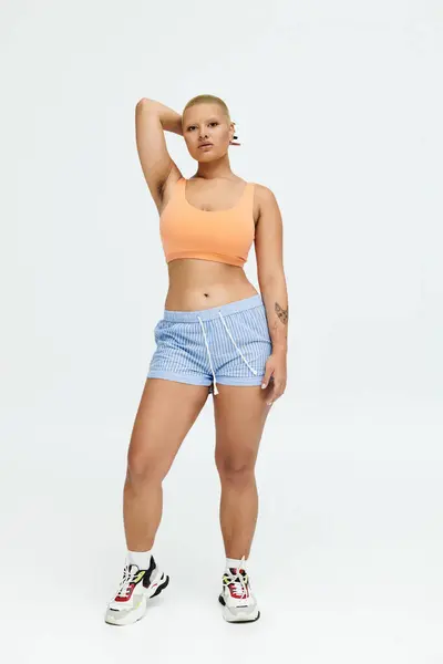 Uma jovem careca posa confiantemente em trajes vibrantes, exalando vibrações de verão e estilo. — Fotografia de Stock