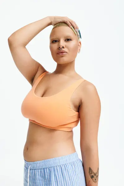 A young bald woman confidently poses in bright clothing, exuding style and personality. — Stock Photo