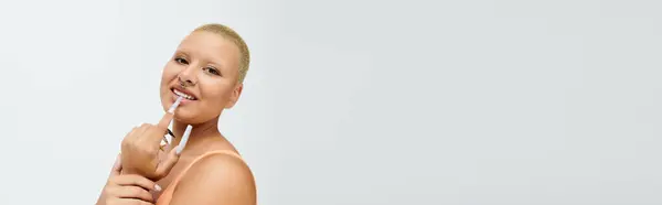 Sporting bold attire, a young bald woman expresses her vibrant personality with a playful gesture. — Stock Photo