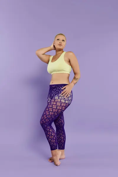 A young bald woman showcases her vibrant outfit with confidence, striking a bold pose. — Stock Photo