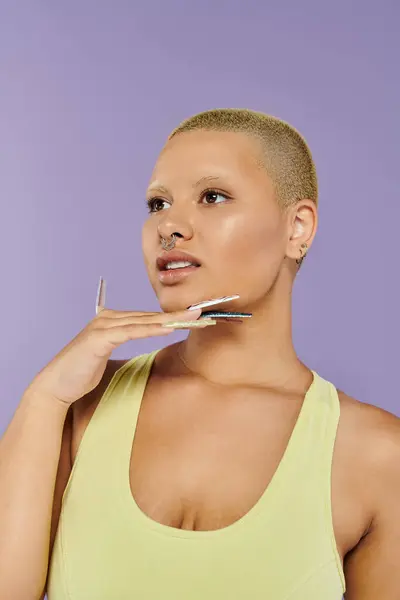 A young bald woman exudes confidence while showcasing her vibrant attire and nail art. — Stock Photo