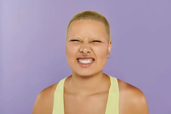 A young bald woman with a big smile showcases her vibrant outfit, reflecting pure happiness. — Stock Photo