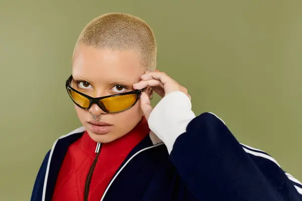A vibrant young woman with a shaved head showcases her unique style while striking a pose. — Stock Photo