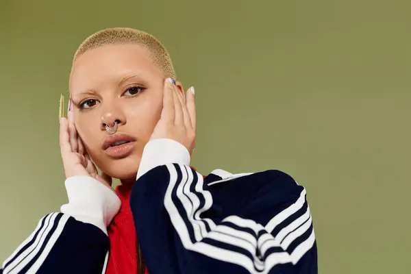 A young bald woman in colorful clothing expresses her individuality while striking a pose. — Stock Photo