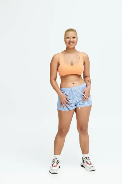 A young bald woman showcases vibrant style and confidence with a bright smile and playful demeanor. — Stock Photo