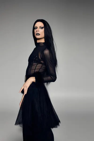 A striking drag queen showcases a bold look in a stylish black ensemble while capturing attention effortlessly. — Stock Photo