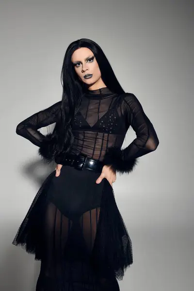 A confident drag queen showcases their fashionable black outfit with striking details, exuding charisma. — Stock Photo