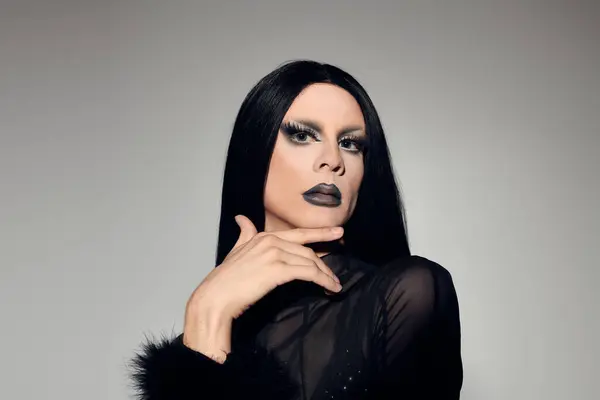 A fashionable gender fluid person showcases a striking black outfit, exuding elegance and confidence. — Stock Photo