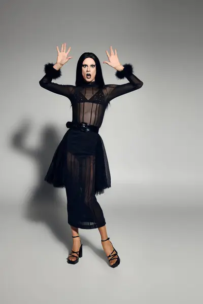 The fashionable drag queen poses dramatically, expressing art and confidence in a sleek black ensemble. — Stock Photo
