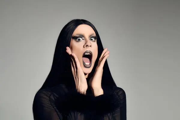 Die modebewusste Drag Queen präsentiert sich in kraftvoller Pose mit markantem Make-up vor schnittiger Kulisse. — Stockfoto