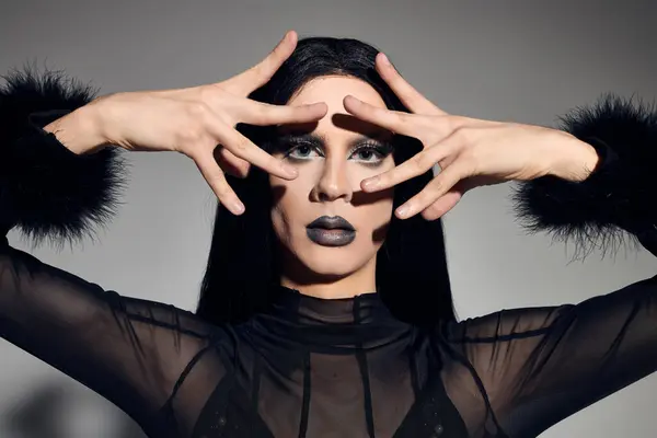 An elegant drag queen poses fashionably, expressing creativity and confidence with bold gestures and makeup. — Stock Photo