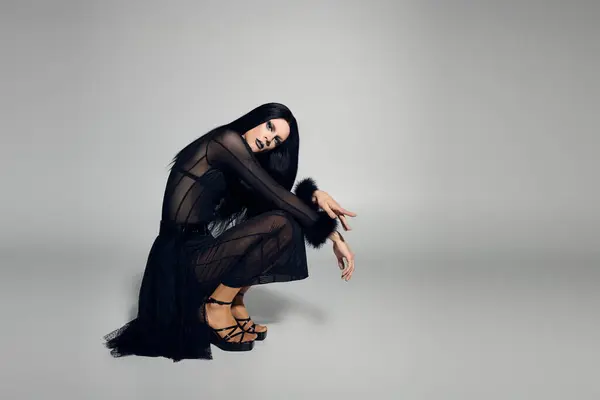 A confident drag queen poses in an elegant black outfit with a modern twist, exuding bold energy. — Stock Photo