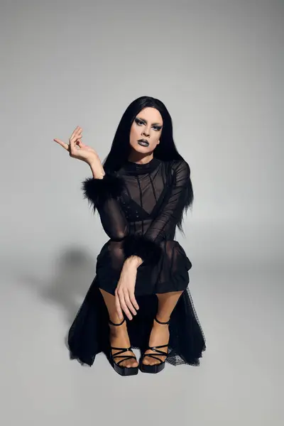 A fashionable gender fluid individual showcases their stylish black outfit with poise and confidence. — Stock Photo
