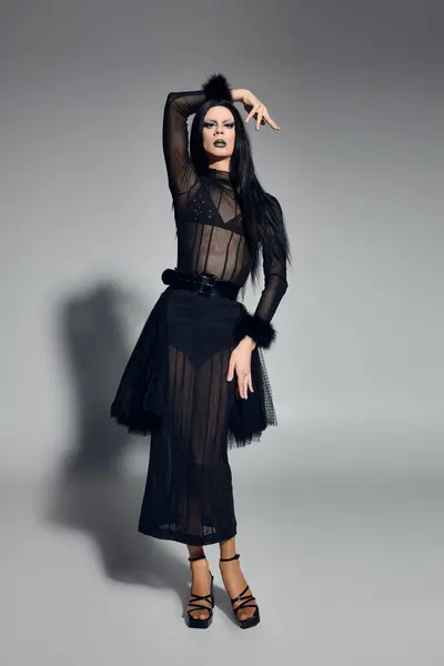 Um indivíduo fluido gênero na moda mostra seu estilo único em um conjunto preto impressionante. — Fotografia de Stock