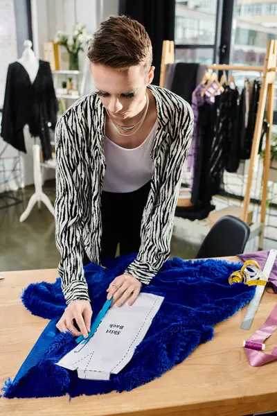 A designer meticulously crafts a striking garment from luxurious fabric in their artistic workspace. — Stock Photo