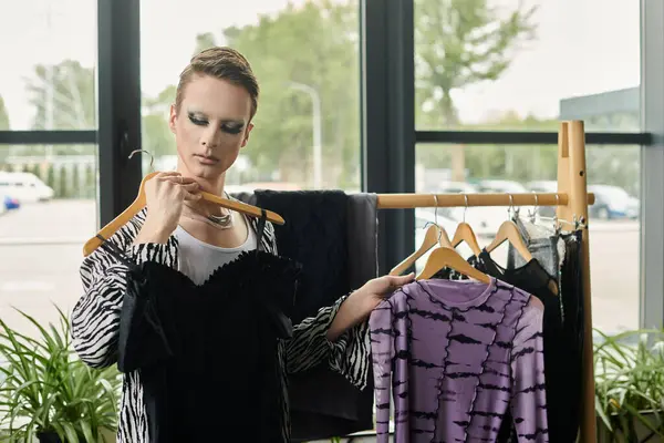 A stylish transgender designer selects fabrics, showcasing creativity in a contemporary fashion studio. — Stock Photo