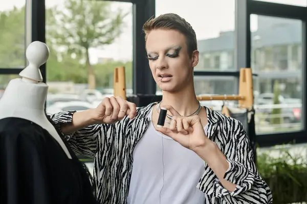 In a lively studio, a gender-fluid fashion designer crafts innovative styles with flair and precision. — Stock Photo