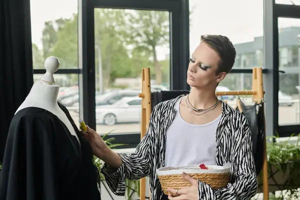Un designer fluide de genre à la mode se concentre sur la confection de vêtements uniques tout en étant entouré d'une créativité vibrante. — Photo de stock