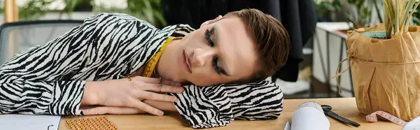 Stylish transgender designer ponders ideas while surrounded by colorful materials and tools in the studio. — Stock Photo