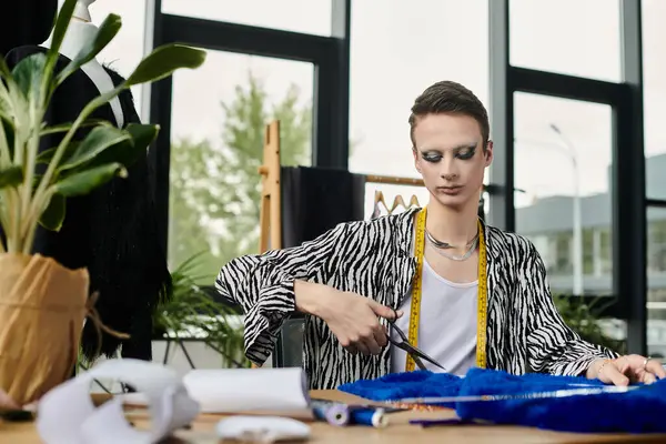 A stylish designer skillfully cuts fabric, surrounded by an inspiring workspace filled with creativity. — Stock Photo