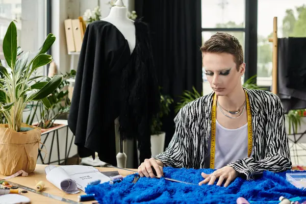 In a creative studio, a gender fluid fashion designer skillfully assembles vibrant fabrics for a new collection. — Stock Photo