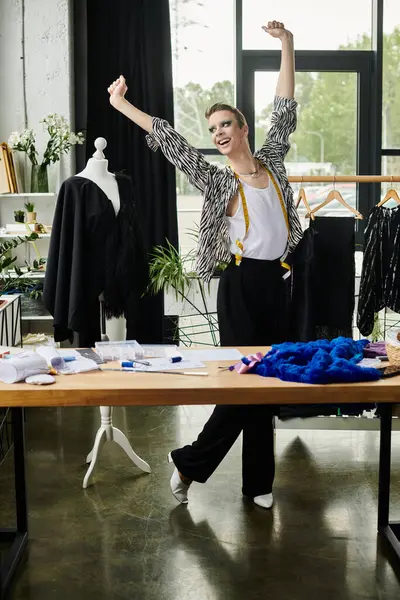 A stylish designer celebrates creativity while working on innovative fashion pieces in their studio. — Stock Photo