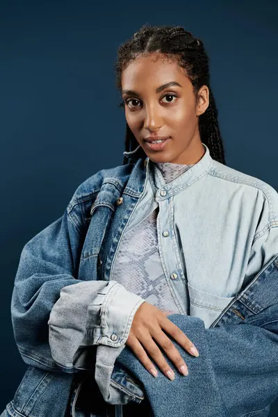 La hermosa joven posa con confianza en el denim elegante con una sonrisa elegante. - foto de stock