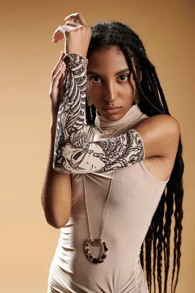 The stylish young woman showcases her fashion with intricate arm jewelry and a chic outfit. — Stock Photo