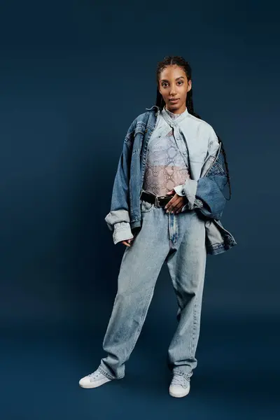 A young woman showcases her unique fashion sense in a striking denim ensemble and intricate top. — Stock Photo