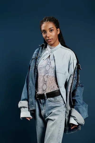 A confident young woman elegantly poses in chic denim, exuding contemporary fashion flair. — Stock Photo