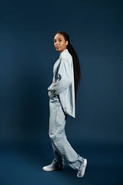 Una bella giovane donna trasuda fiducia nel denim rilassato, mostrando il suo stile elegante. — Foto stock