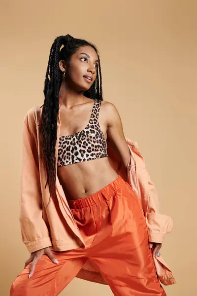 The young woman exudes confidence in her chic leopard print outfit, striking a dynamic pose. — Stock Photo