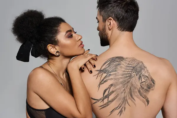 A couple shares a tender gaze, highlighting their deep connection and stunning tattoos. — Stock Photo