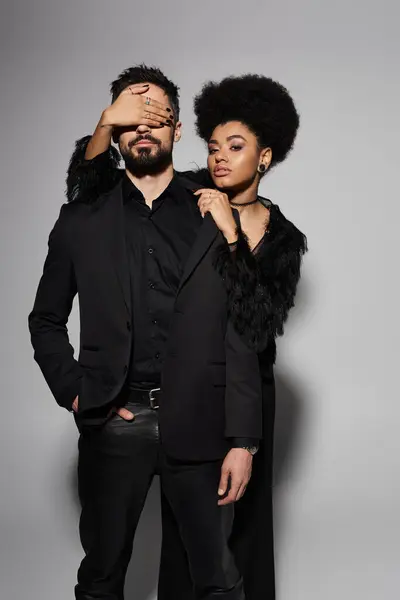 A stylish couple expresses deep affection and artistry through a dynamic pose and striking outfits. — Stock Photo
