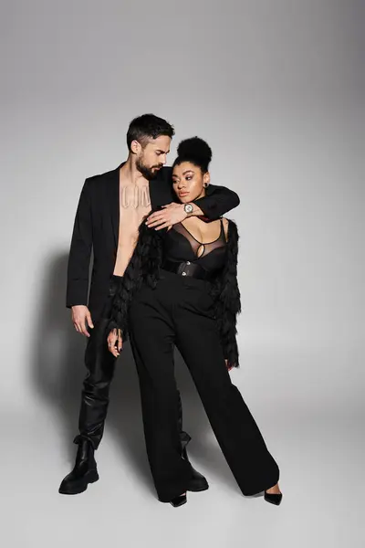 A couple radiates love and style, showcasing their fashionable outfit choices in a playful moment. — Stock Photo
